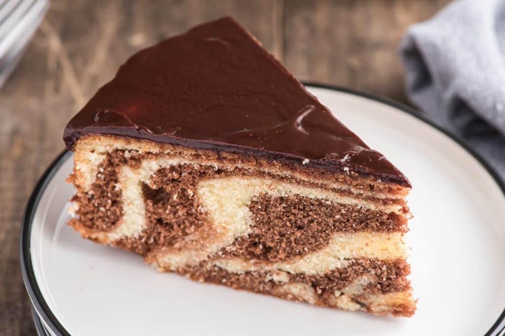 A slice of marble cake on a white plate.