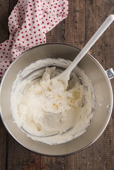 Whipped cream beaten until stiff in a silver bowl.