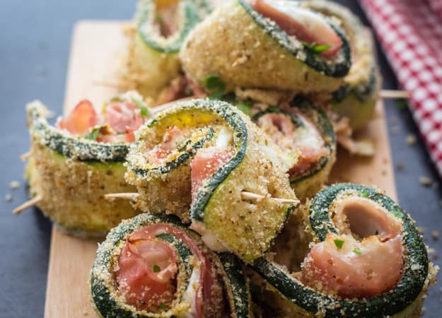 breaded zucchini rollups on a wooden board