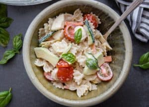creamy italian pasta salad in a ceramic bowl with a fork.