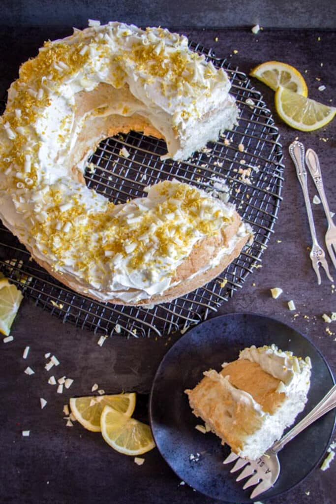 Cake on a wire rack and a slice on a black plate.