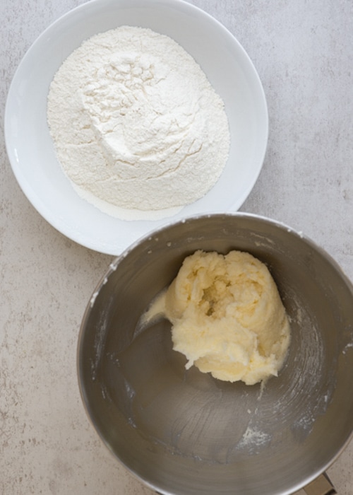 Butter creamed and the dry ingredients in a white bowl.