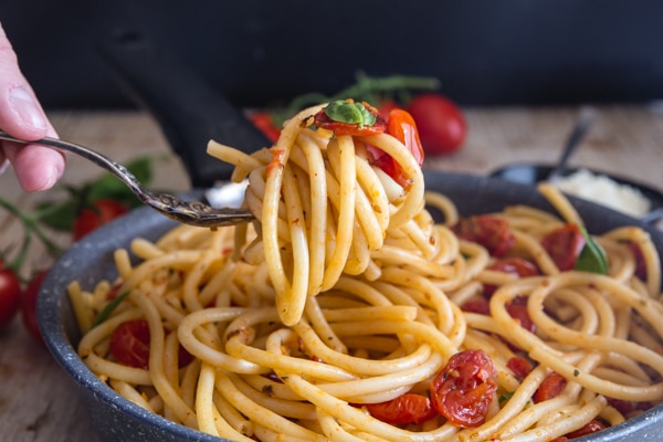 fork of roasted tomatoes and bucatini pasta