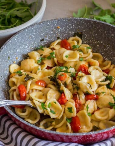 Tomato pasta in a red pan.