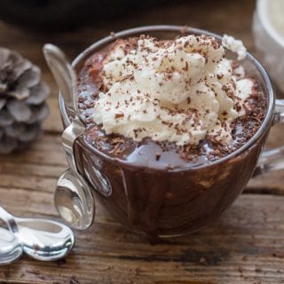 thick Italian hot chocolate in a glass mug topped with whipped cream and grated chocolate