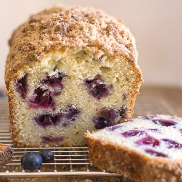 blueberry bread a cut piece on a wire rack