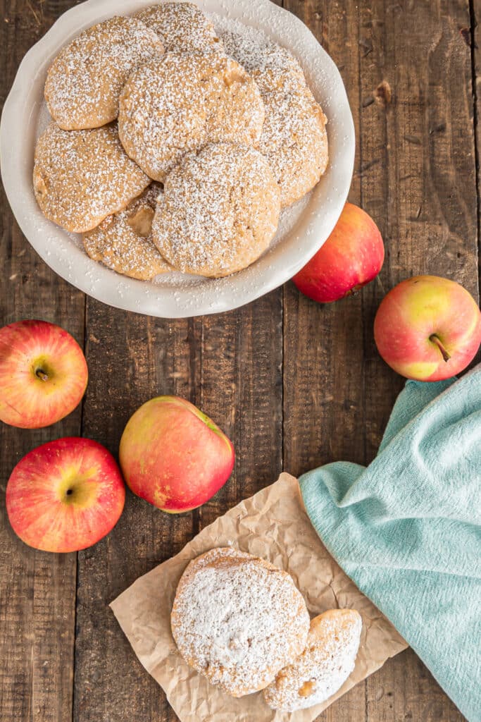 Two cookies on brown paper and some in a white plate.