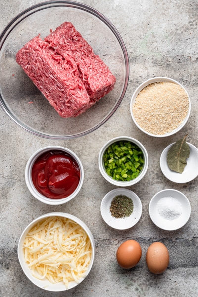Ingredients for the meatloaf on a grey board.