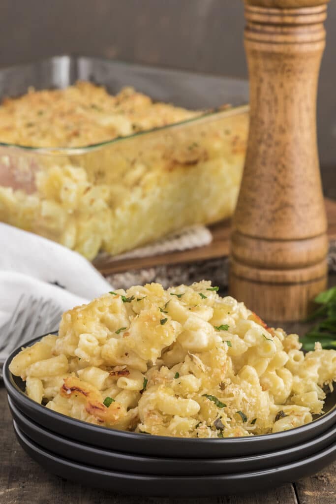 The baked mac and cheese in the pan and some on a plate.