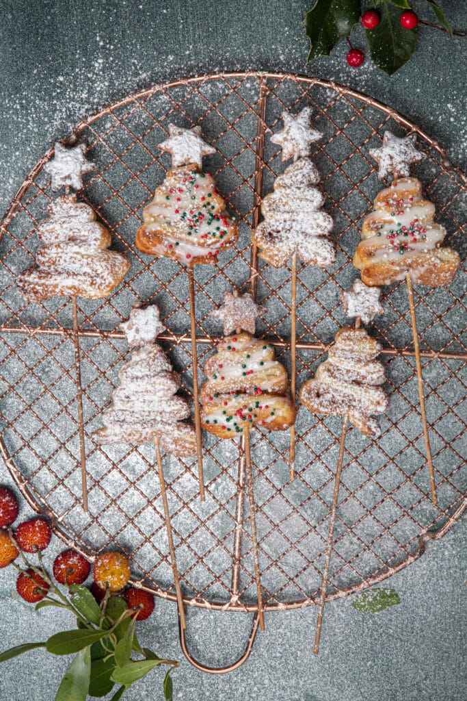 Seven puff pastry Christmas trees on a wire rack.