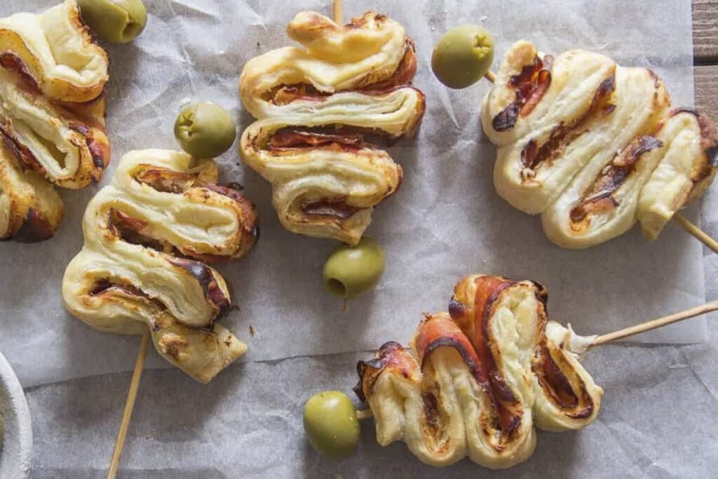 Puff pastry Christmas tree appetizers on parchment paper.