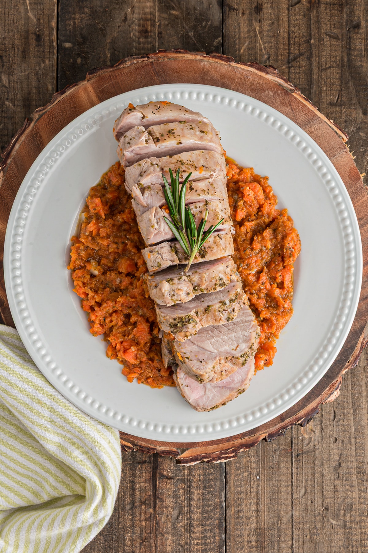 The sliced pork roast on a white plate with carrots.