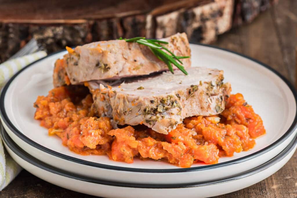 Two slices of pork on a plate with carrots.