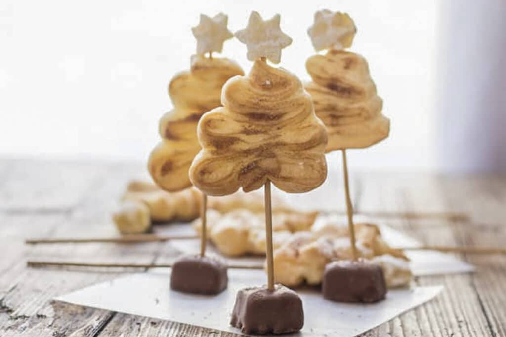 Three puff pastry Christmas trees on parchment paper.