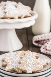 Cinnamon cookies on a cake stand and some on a plate.