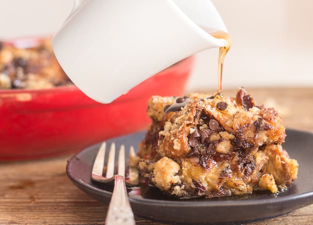 pouring maple syrup on a piece of french toast casserole