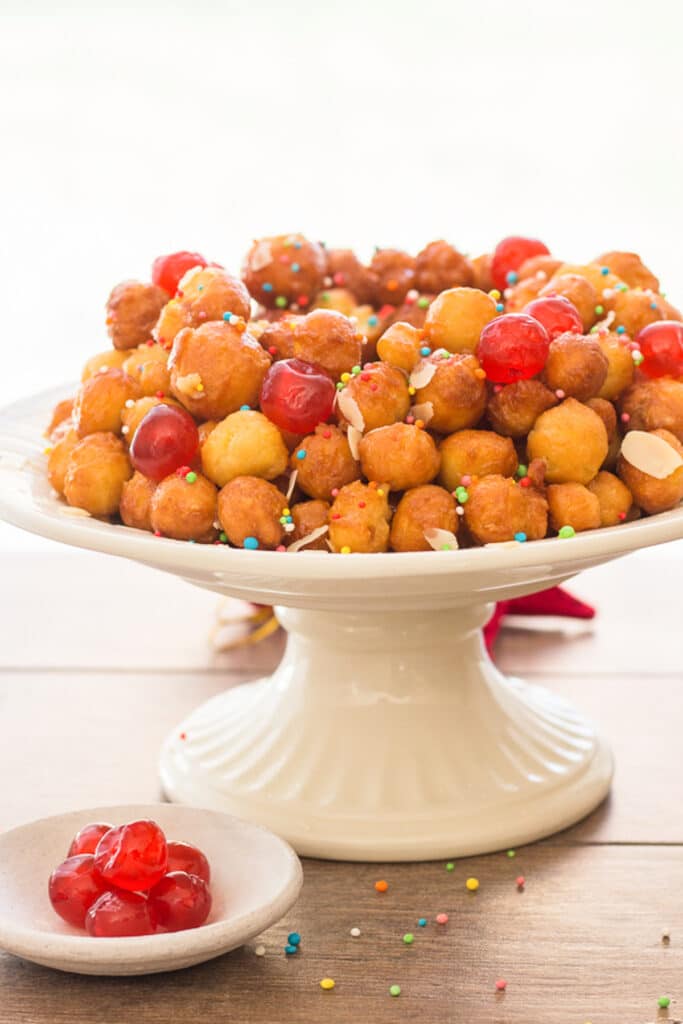 Struffoli on a white cake plate.