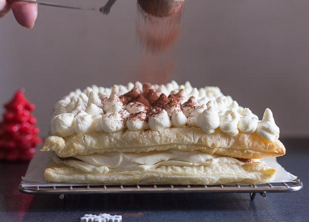 sprinkling cocoa on puff pastry tiramisu