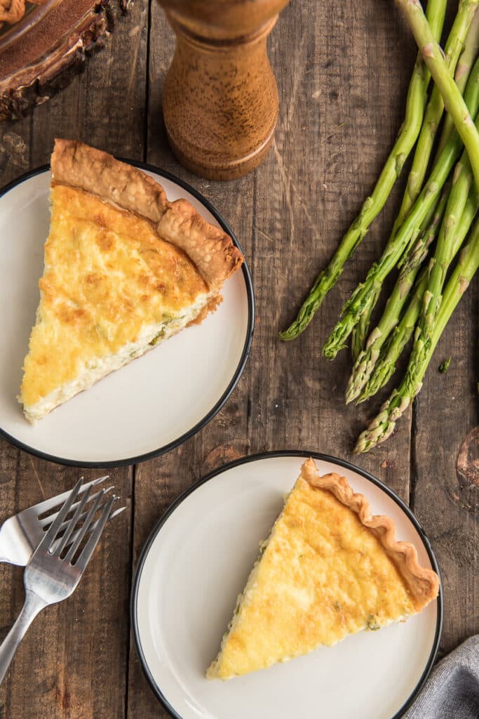 Two slices of quiche on white plates.