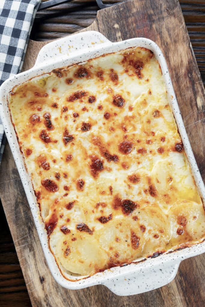 Scalloped potatoes in a white pan.