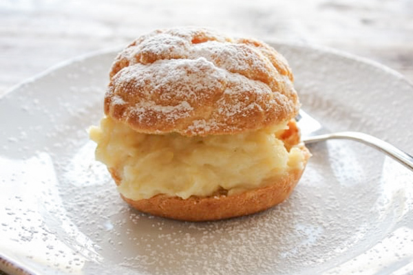 bigne with pastry cream on a white plate