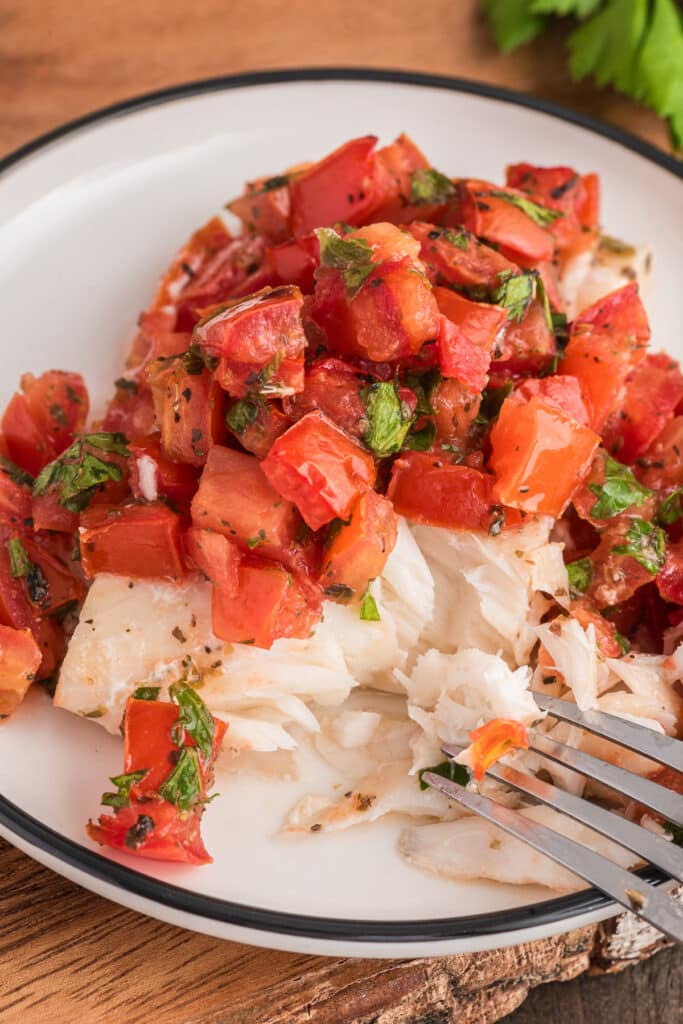 Fish on a white plate with a fork.