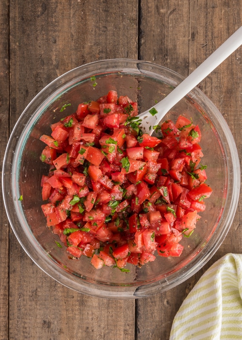 Mixing the tomato mixture in a glass bowl.