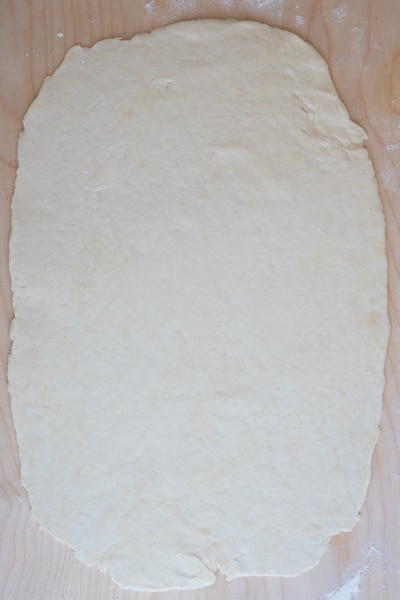 The dough rolled out on a board.