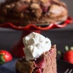 strawberry chocolate cake with a slice on a plate with whipped cream