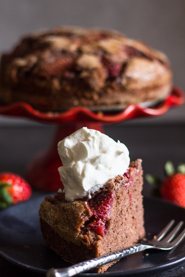 strawberry chocolate cake with a slice on a plate with whipped cream