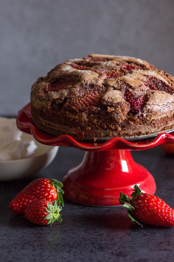 baked chocolate strawberry cake on a red cake stand