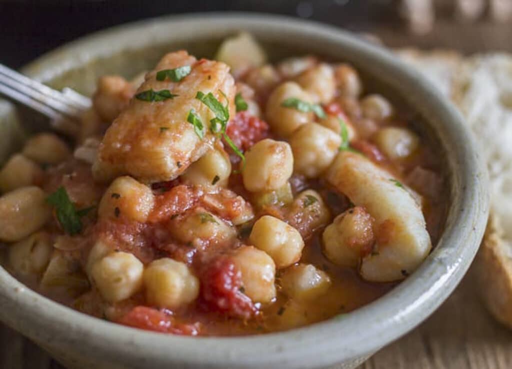 Fish and chickpeas in a grey bowl.