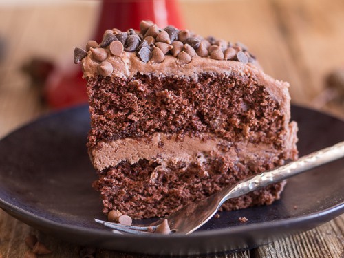 a slice of chocolate cake on a black plate