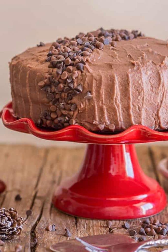 Chocolate cake on a red cake stand.