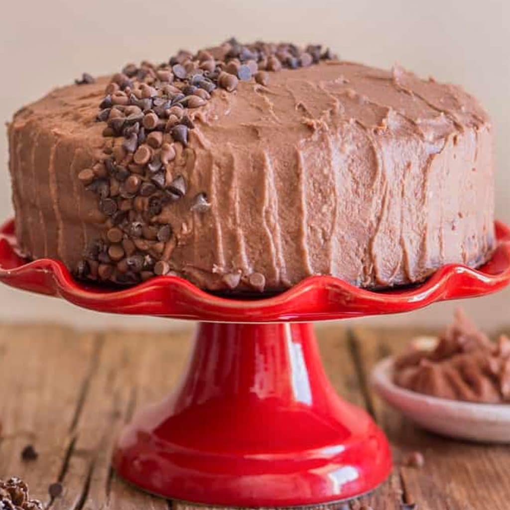 Chocolate cake on a red cake stand.