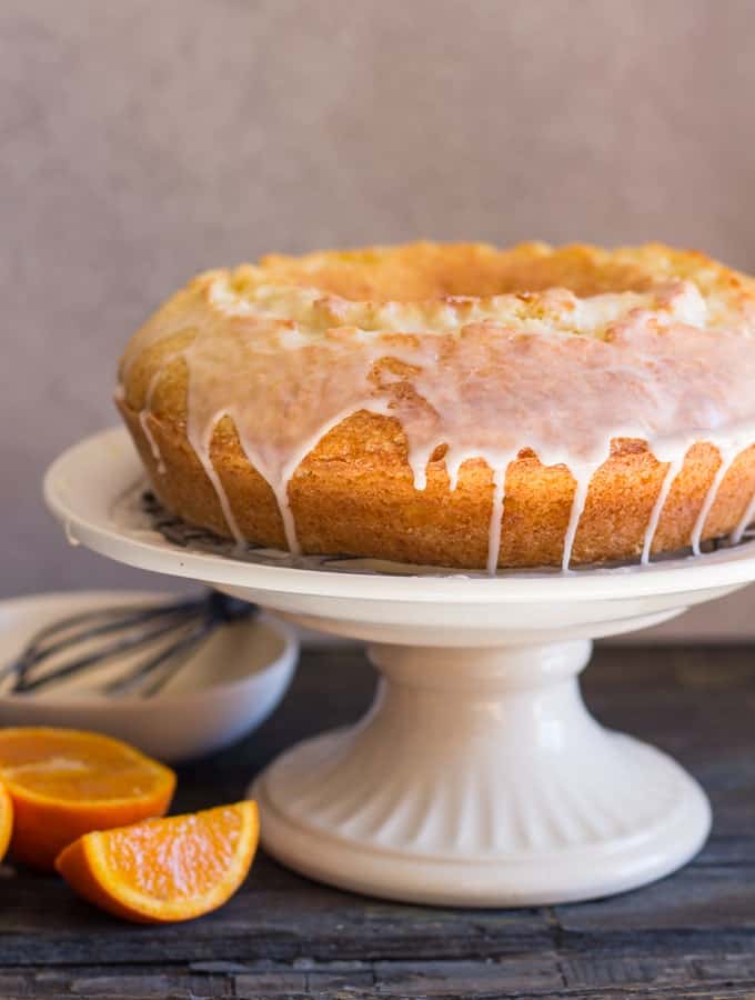 orange bundt cake on a white cake stand