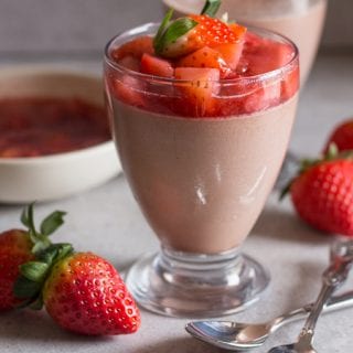 Panna cotta in a glass with fresh strawberry topping on top