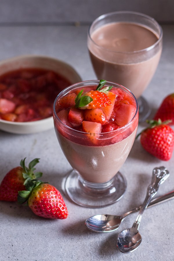 2 glasses of panna cotta one with strawberry topping 
