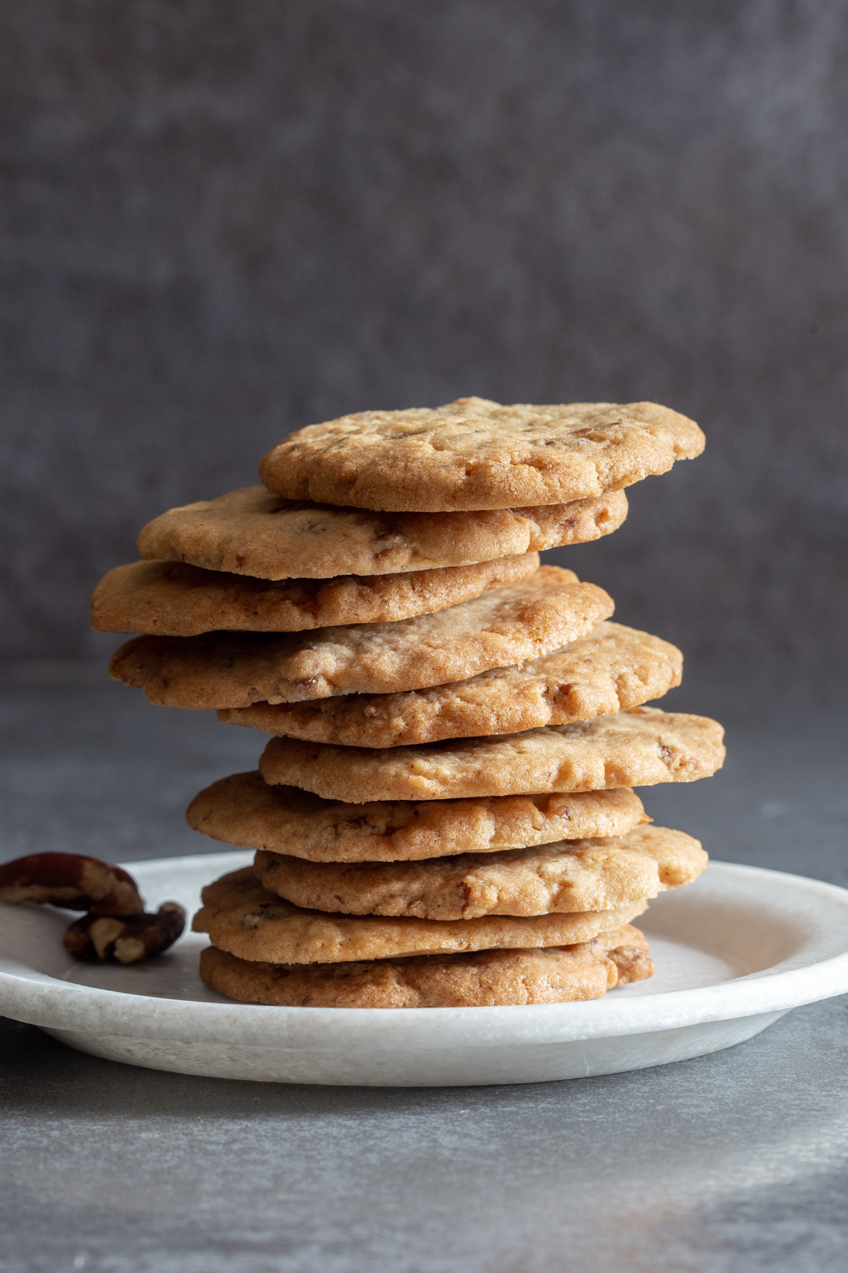 Pecan cookies stacked on a white plate.