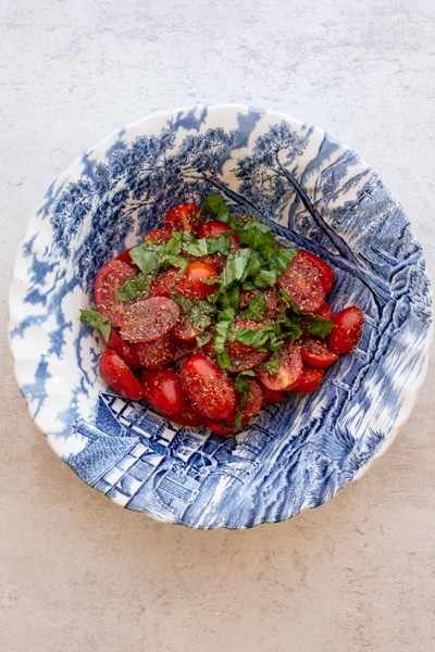 sliced tomatoes and spices in a blue bowl