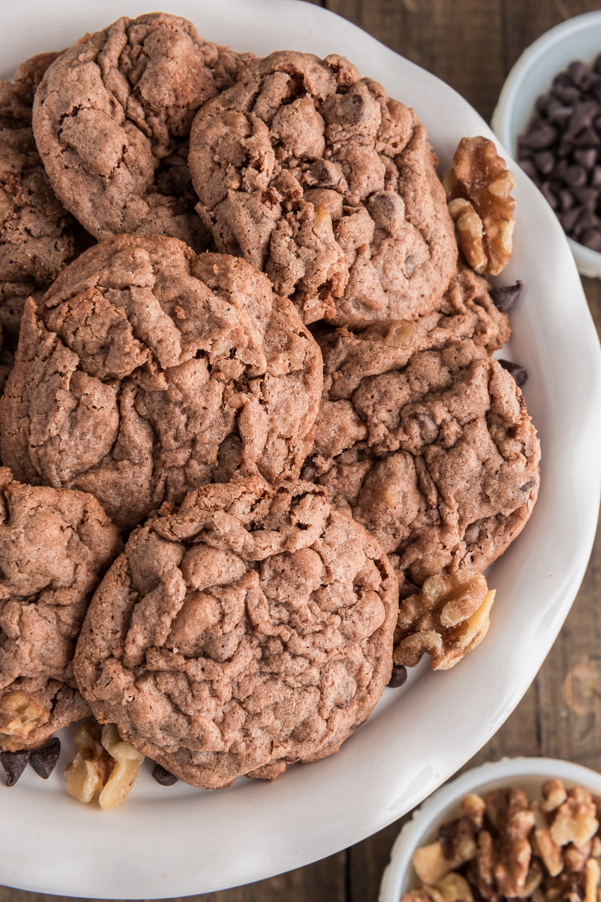 Chocolate chip walnut cookies on a white plate.