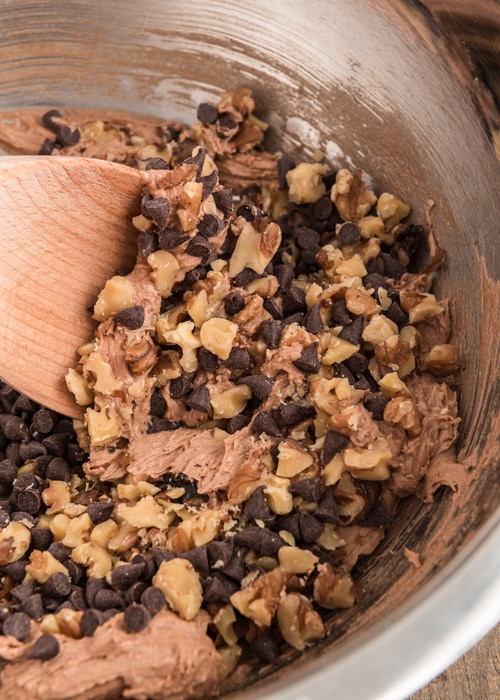 Mixing the nuts and chips into the batter.