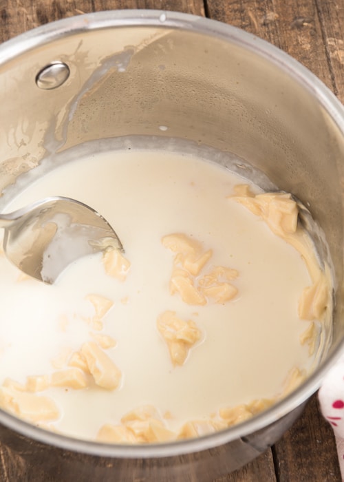 Mixing the cream and white chocolate in a pot.