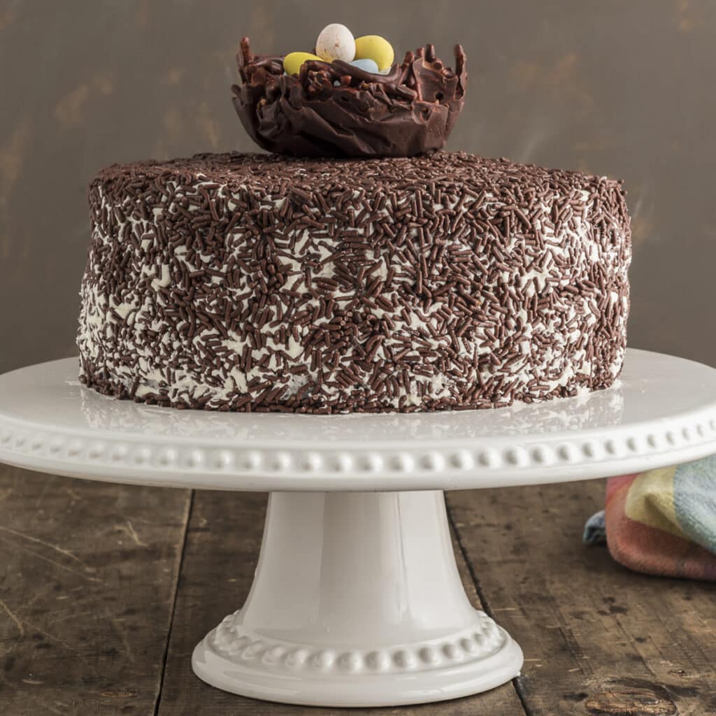 Nest cake on a white cake stand.