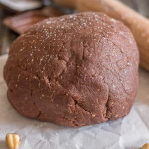 Pie dough on waxed paper with hazelnuts.