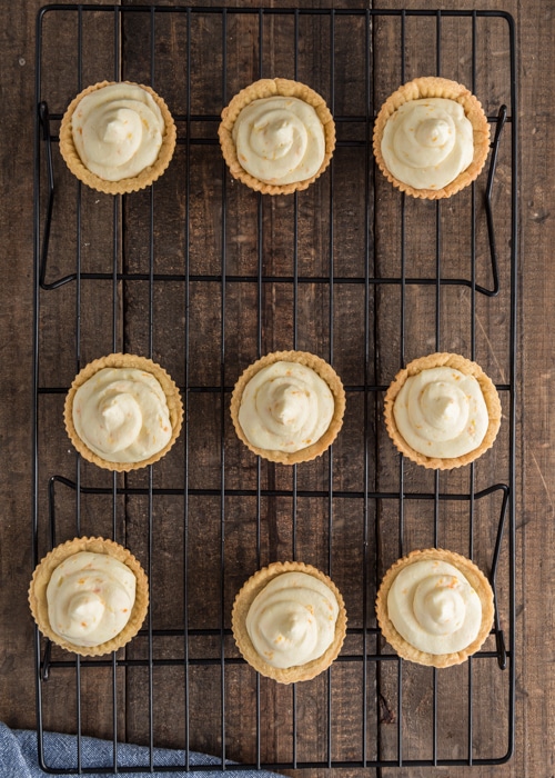 Filled tarts on a wire rack.