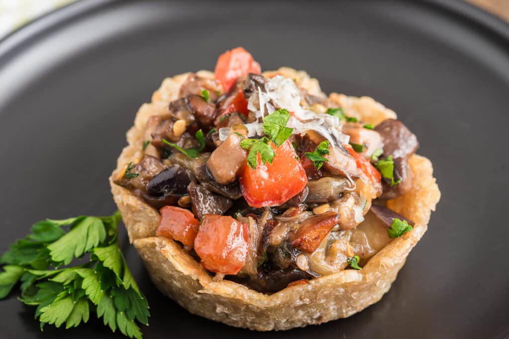 Parmesan potato basket on a black plate.