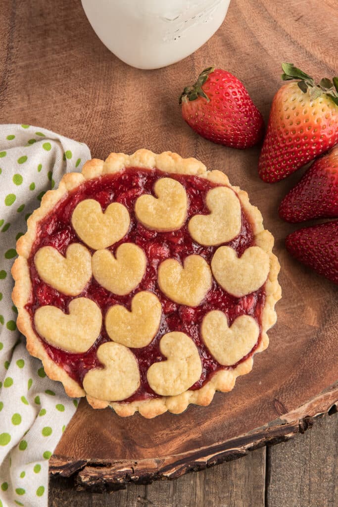 A strawberry tart on a wooden board.