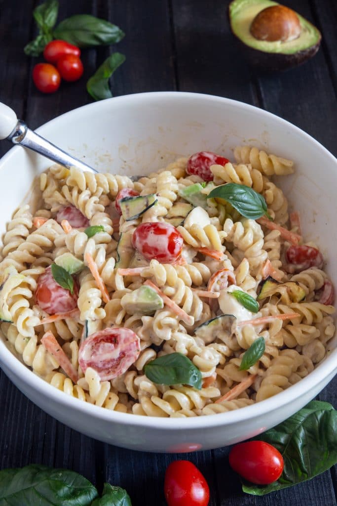 Pasta salad in a white bowl.