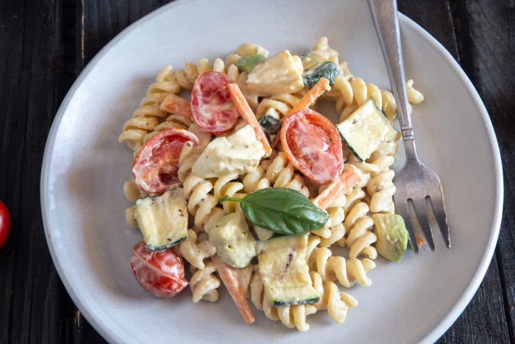 Creamy pasta salad on a white plate.